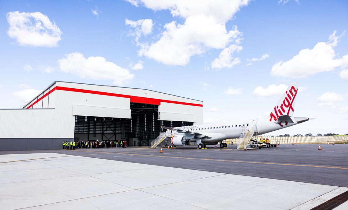 a group of people standing outside a plane