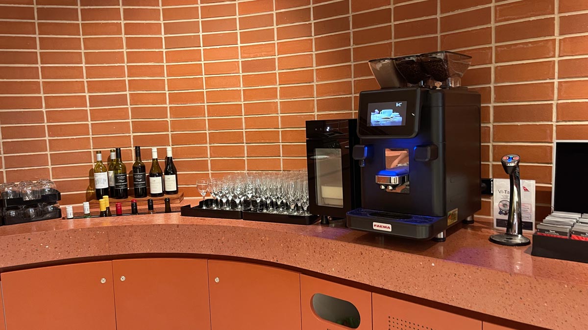 a coffee machine and wine glasses on a counter