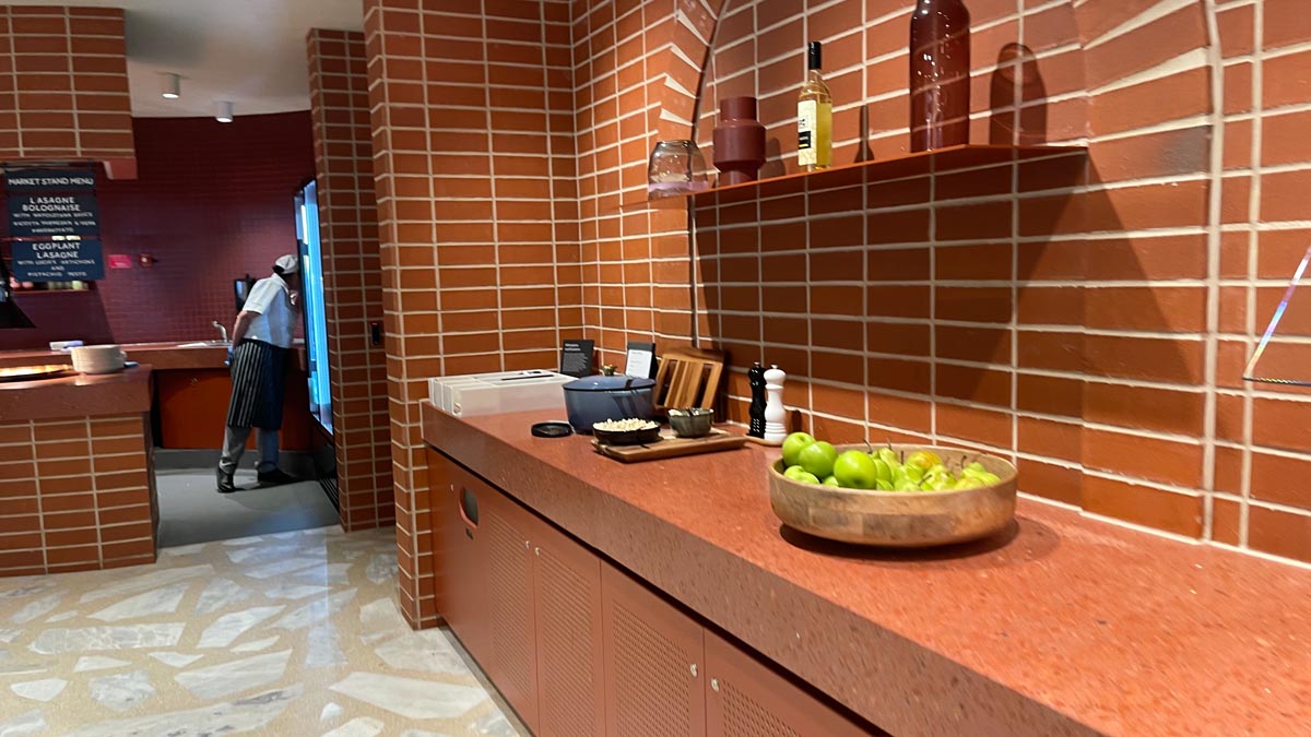 a kitchen with a bowl of fruit and a brick wall