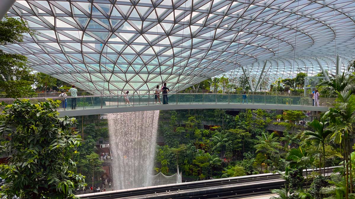 a glass dome with a waterfall in the background