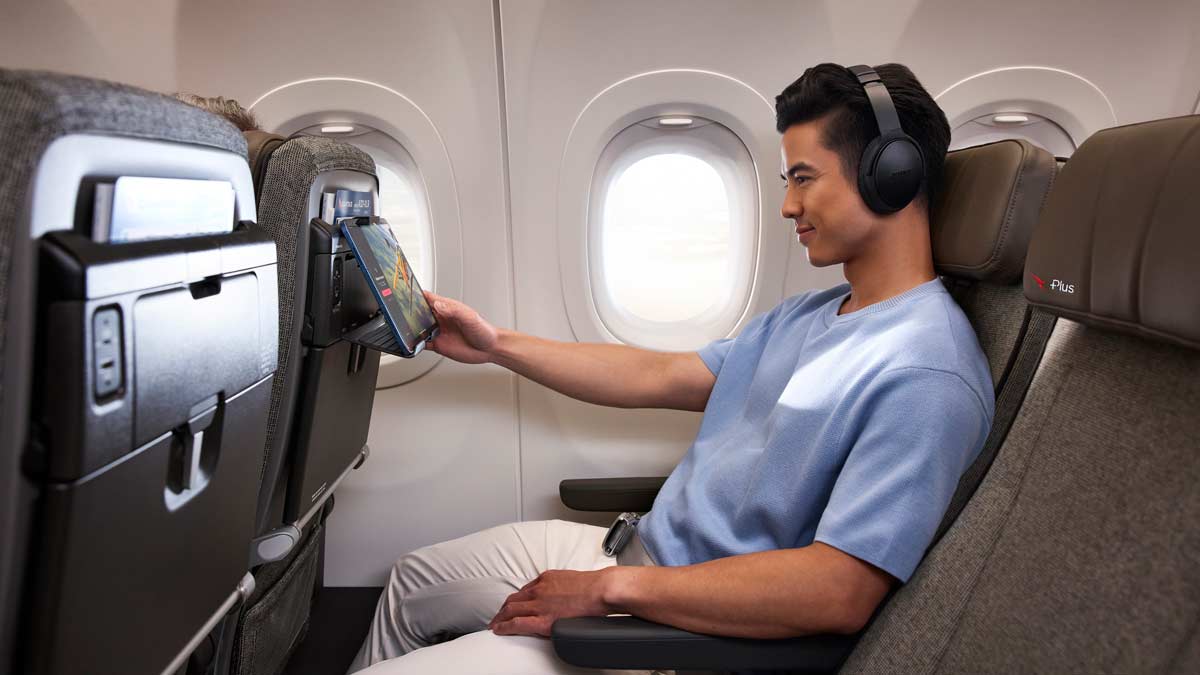 a man sitting in an airplane with headphones on