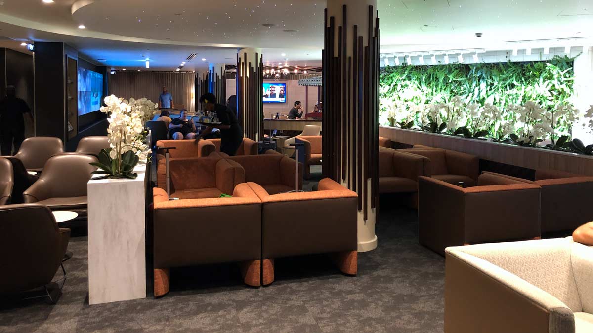 a room with brown couches and plants