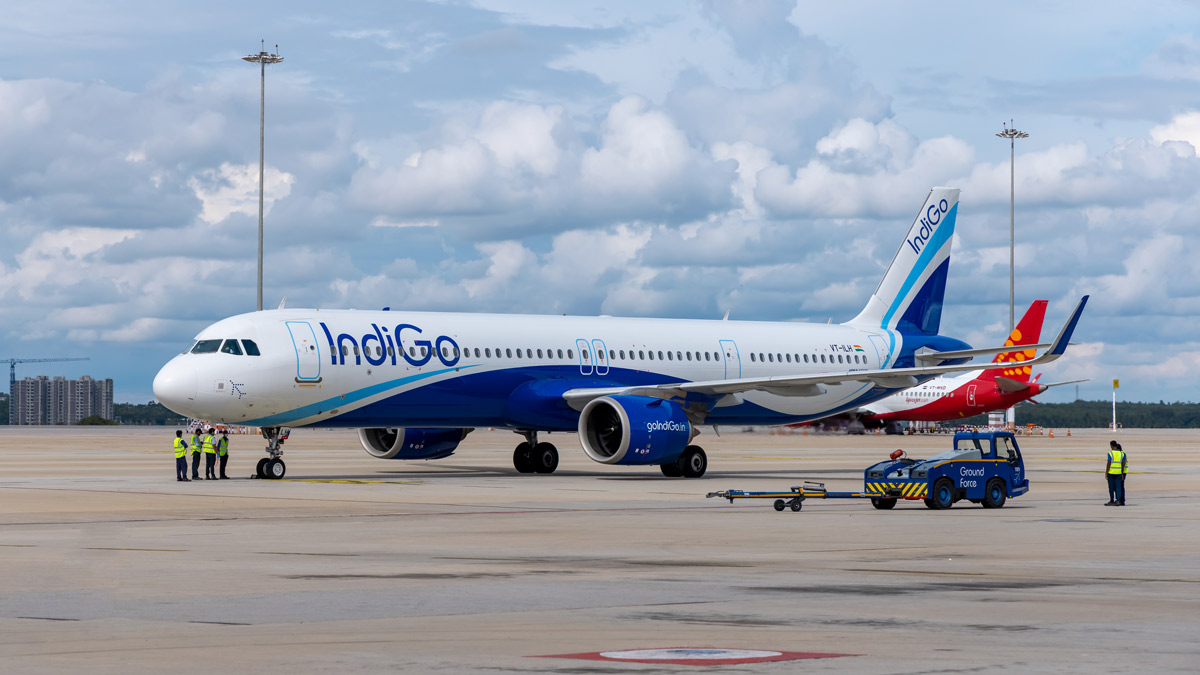 a blue and white airplane on a runway