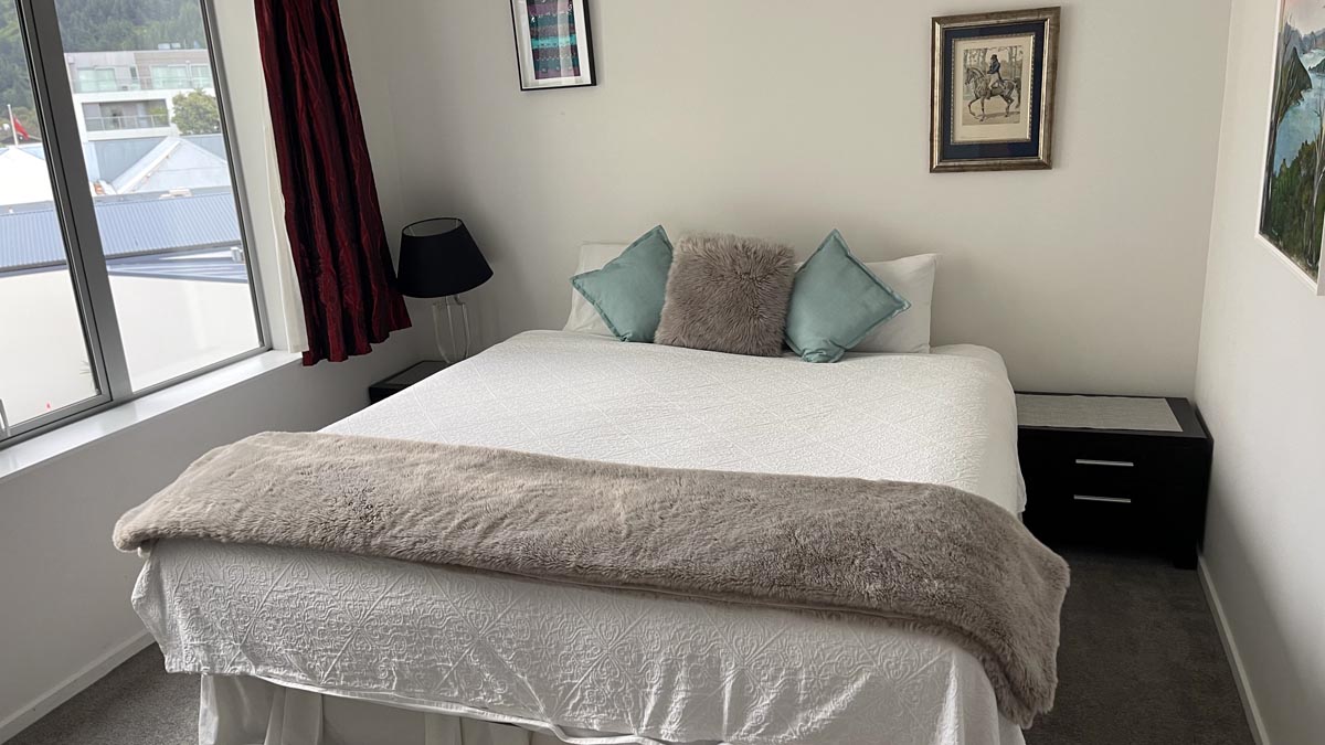 a bed with pillows and a lamp in a room