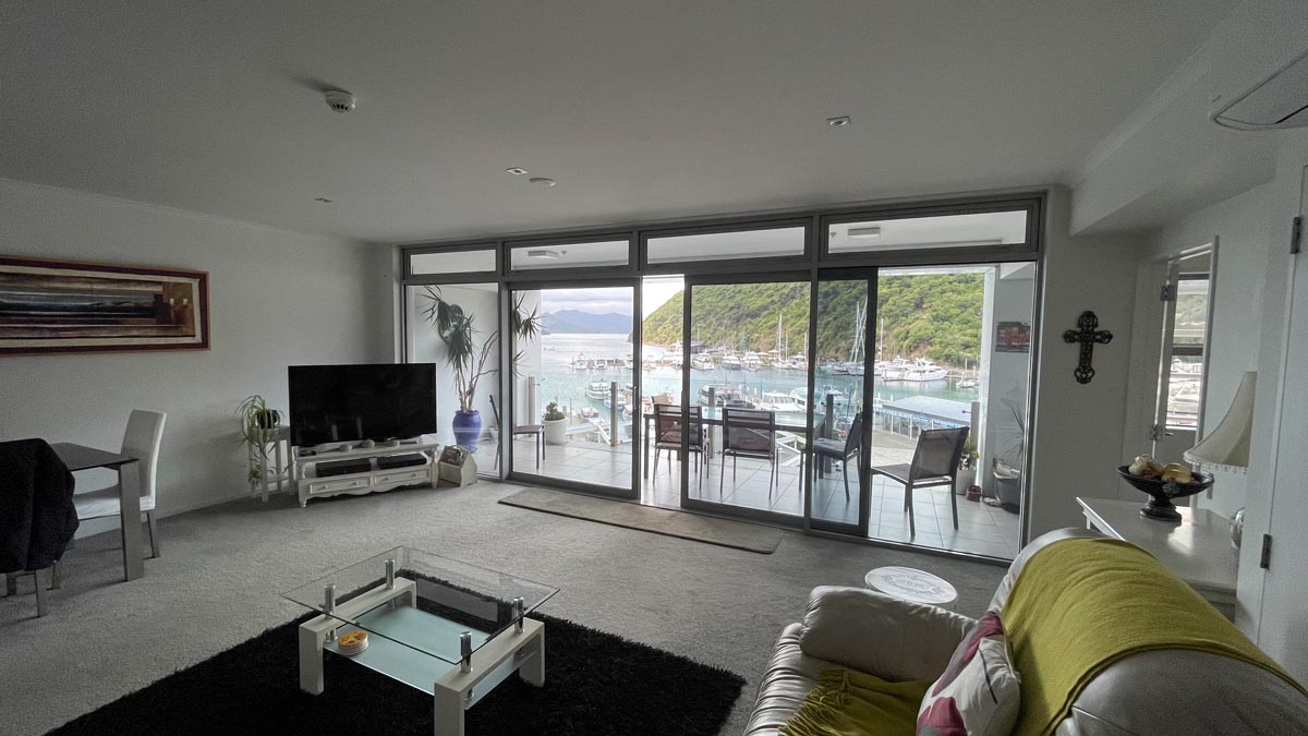 a living room with glass doors and a view of a marina