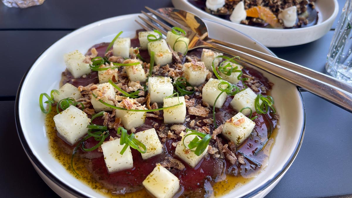 a bowl of food with fork and spoon