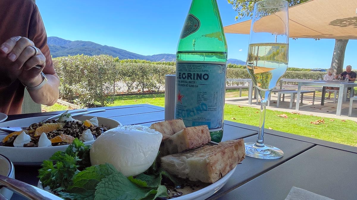 a plate of food and a glass of wine on a table