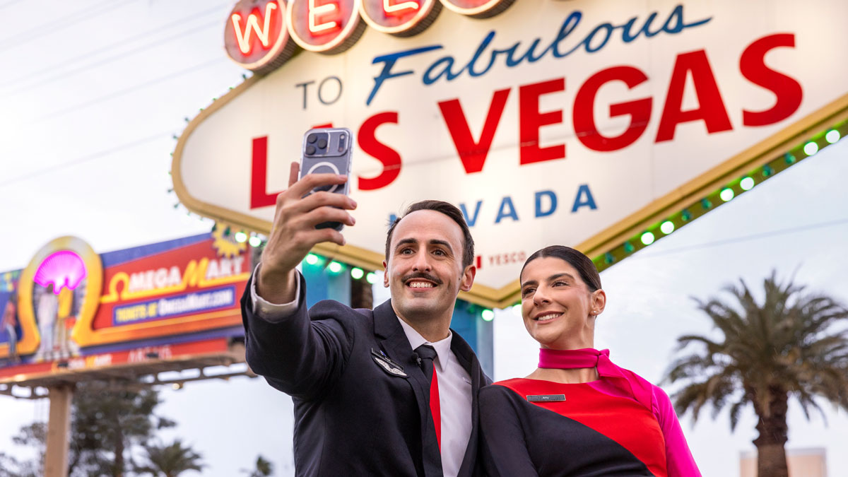 a man and woman taking a selfie in front of a sign