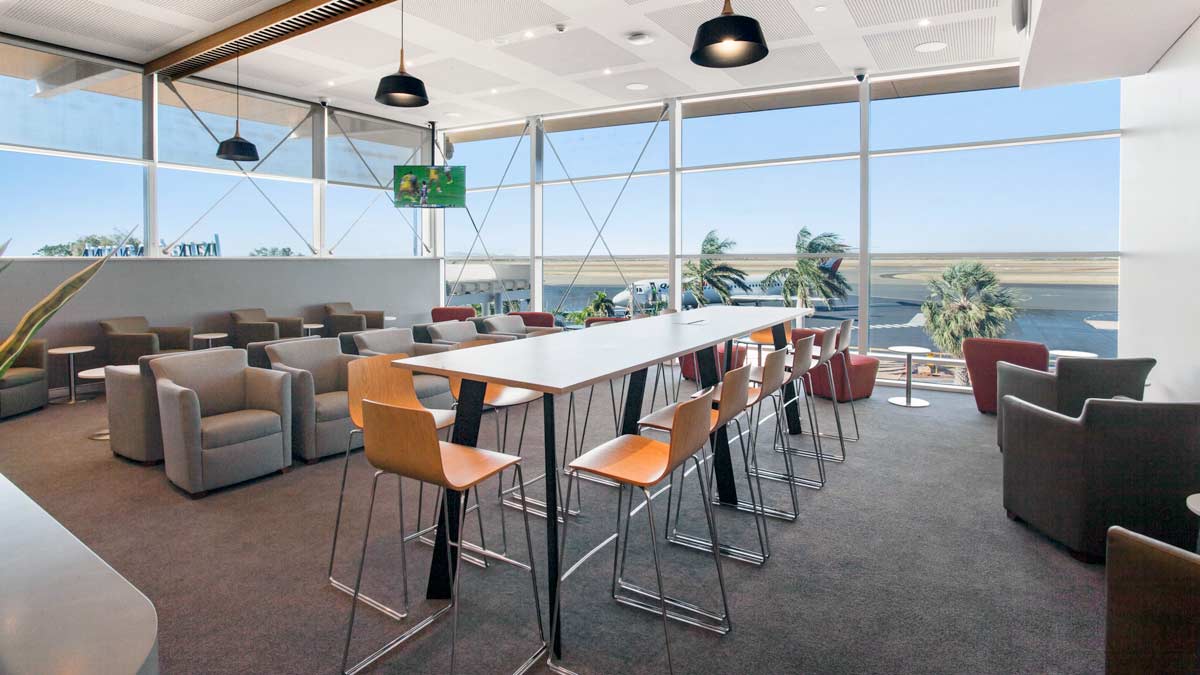 a long table with chairs in a room with large windows