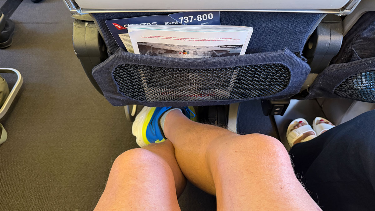 a person's legs and a pocket in a seat